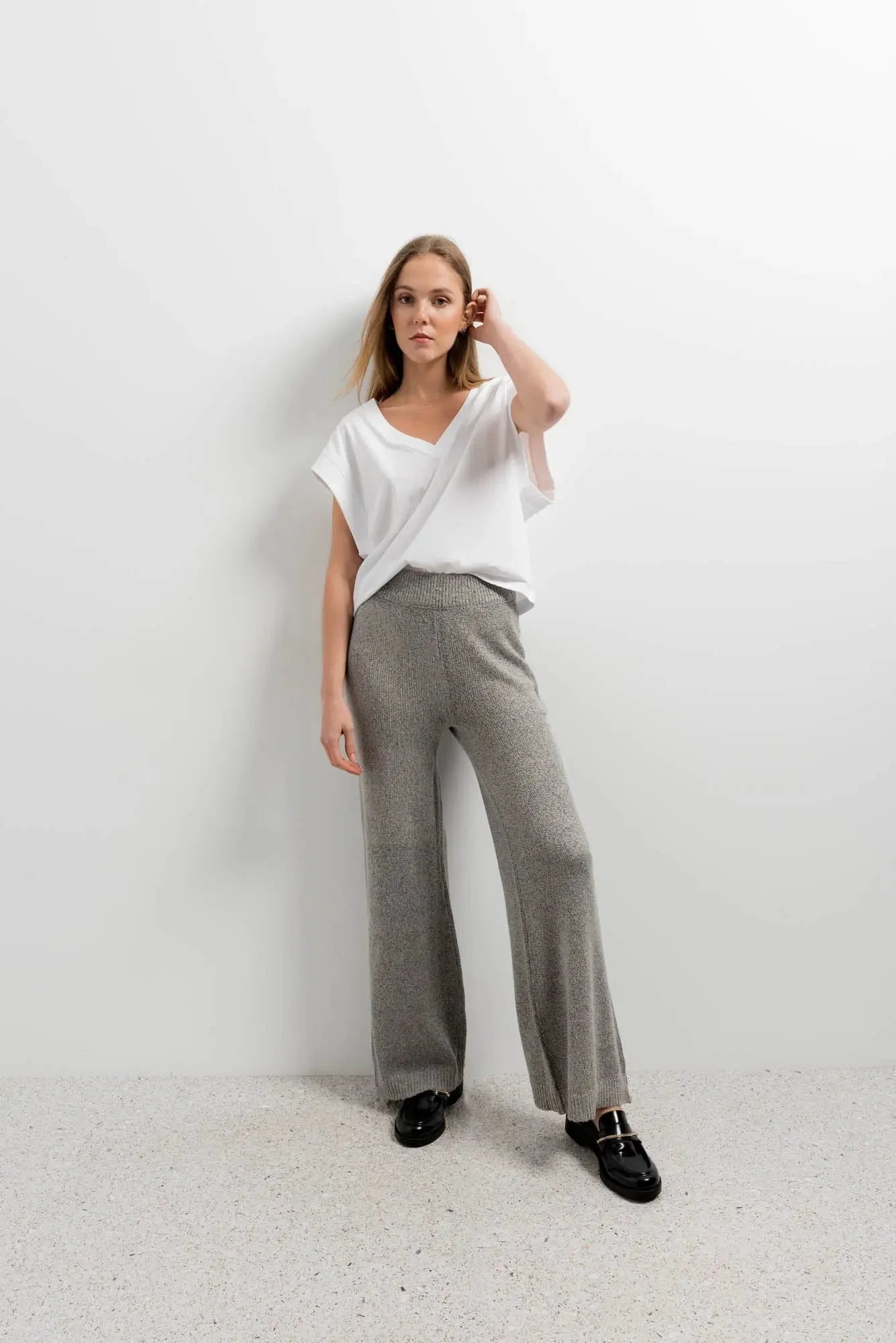 Jeune femme portant un pantalon tricot à jambes larges en gris et blanc