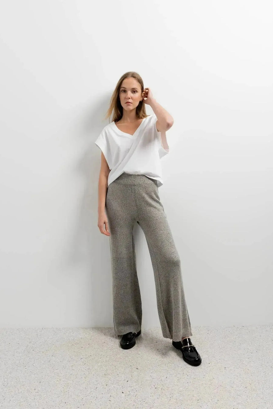 Modèle portant un ensemble pantalon tricot à jambes larges avec un t-shirt blanc, parfait pour femme. Ce pantalon tricot femme offre style et confort.