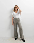 Modèle portant un ensemble pantalon tricot à jambes larges avec un t-shirt blanc, parfait pour femme. Ce pantalon tricot femme offre style et confort.