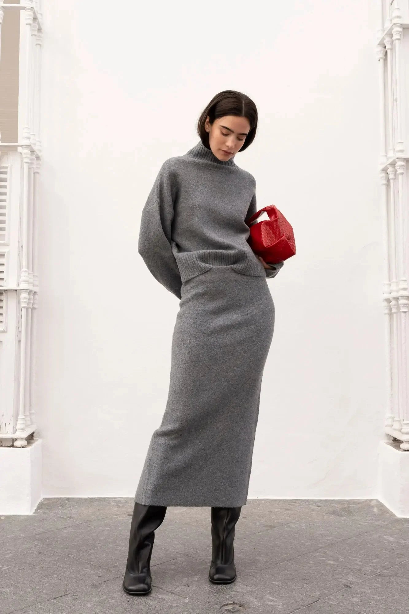 Ensemble maille grise avec pull turtleneck et jupe midi, bottes noires, sac rouge