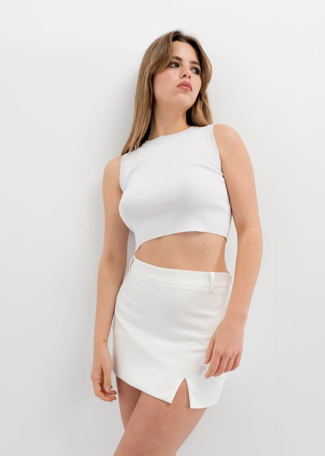 Jeune femme en mini jupe verte, chic et tendance, mettant en valeur la fente latérale, idéale pour toutes les occasions.