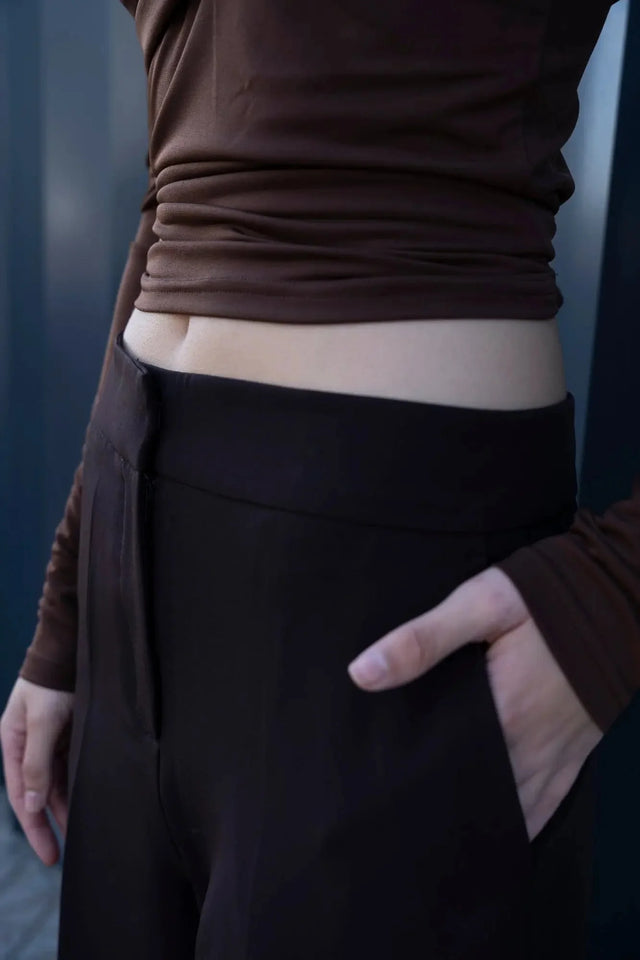 Vue rapprochée du pantalon droit femme, soulignant le confort et le design flatteur de l'ensemble top et pantalons droits marron.
