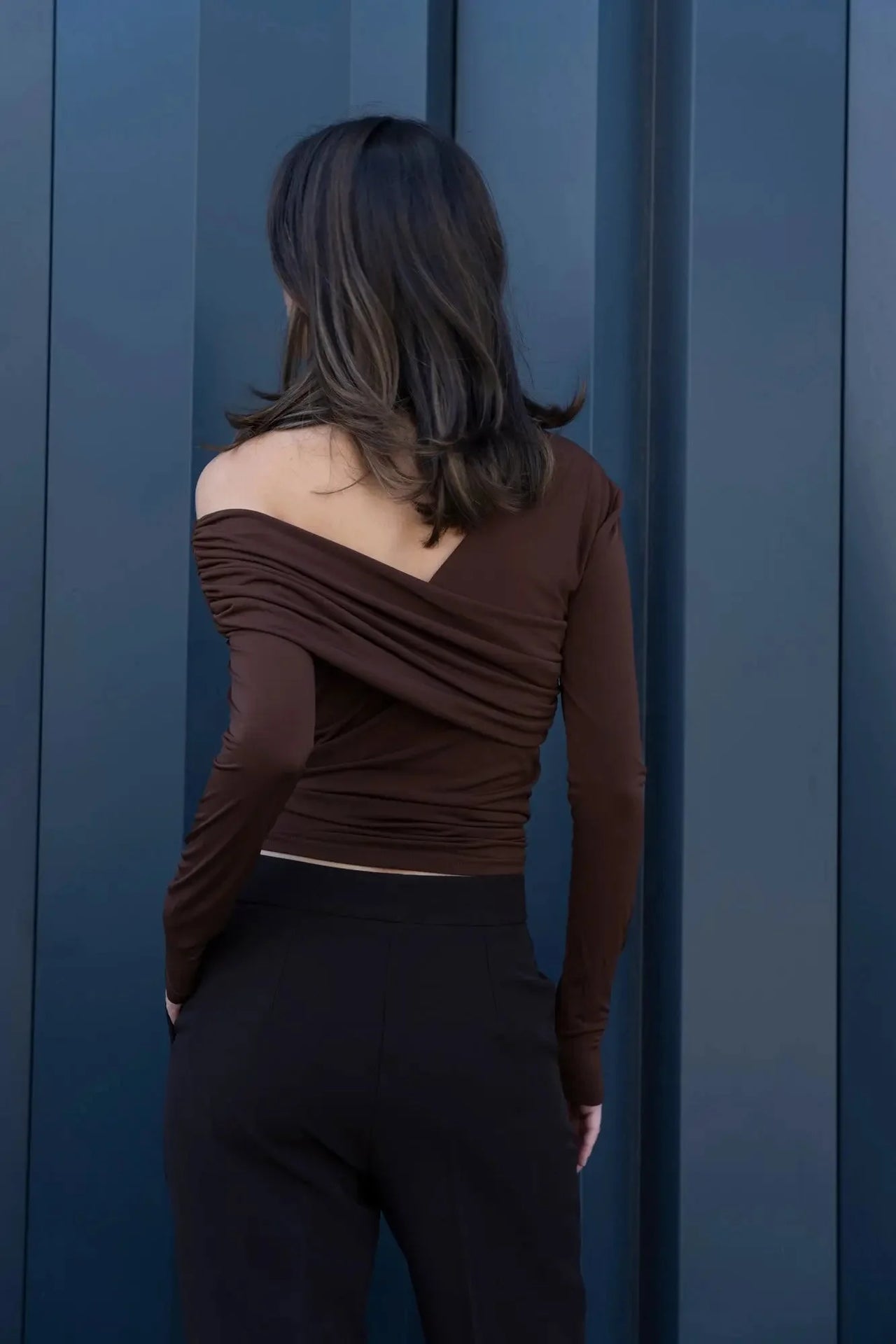 Vue arrière d'un modèle féminin dans un ensemble top et pantalons droits marron, idéale pour mettre en avant la coupe du pantalon droit femme.
