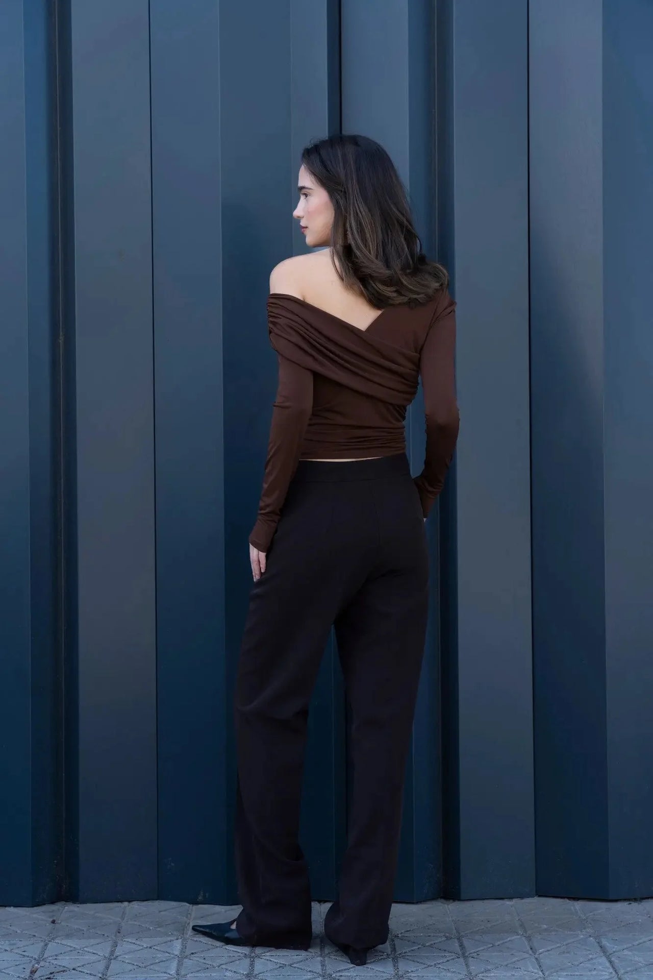 Modèle féminin avec un dos dénudé portant un ensemble top et pantalons droits marron, parfait pour un look sophistiqué en pantalon droit femme.