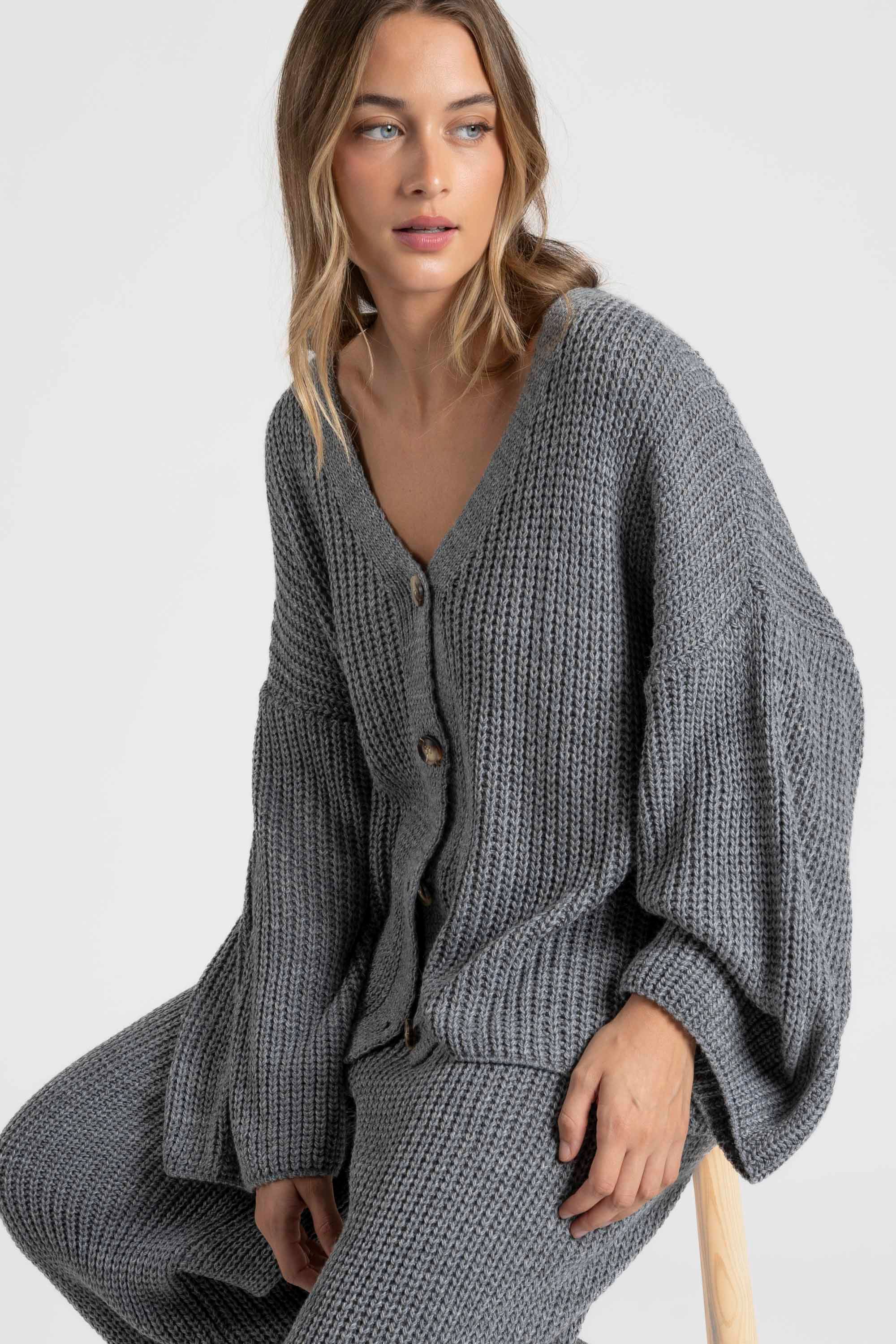 Détail de femme en haut d'ensemble maille femme italien couleur gris, soulevant le haut en tricot.