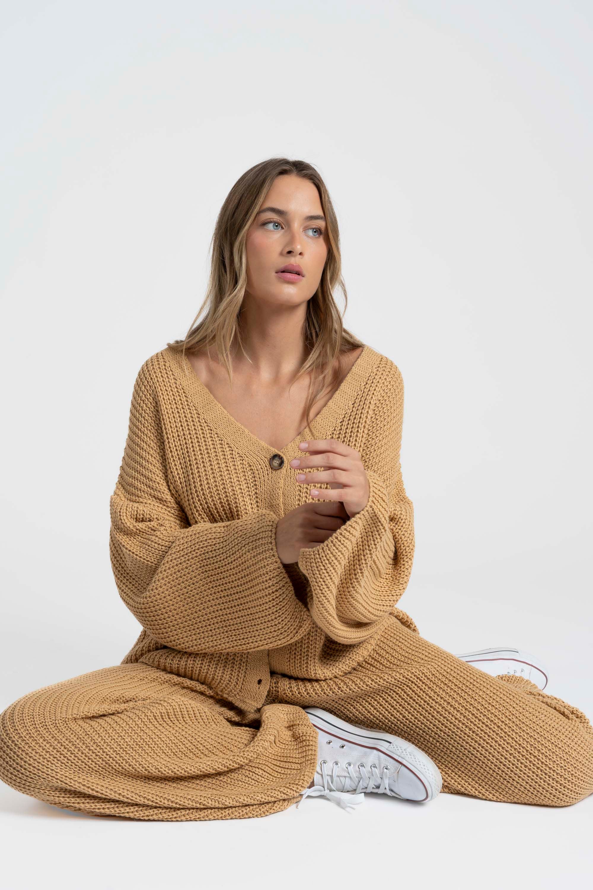 Femme assise portant un ensemble maille femme italien en couleur beige, alliant confort et style.