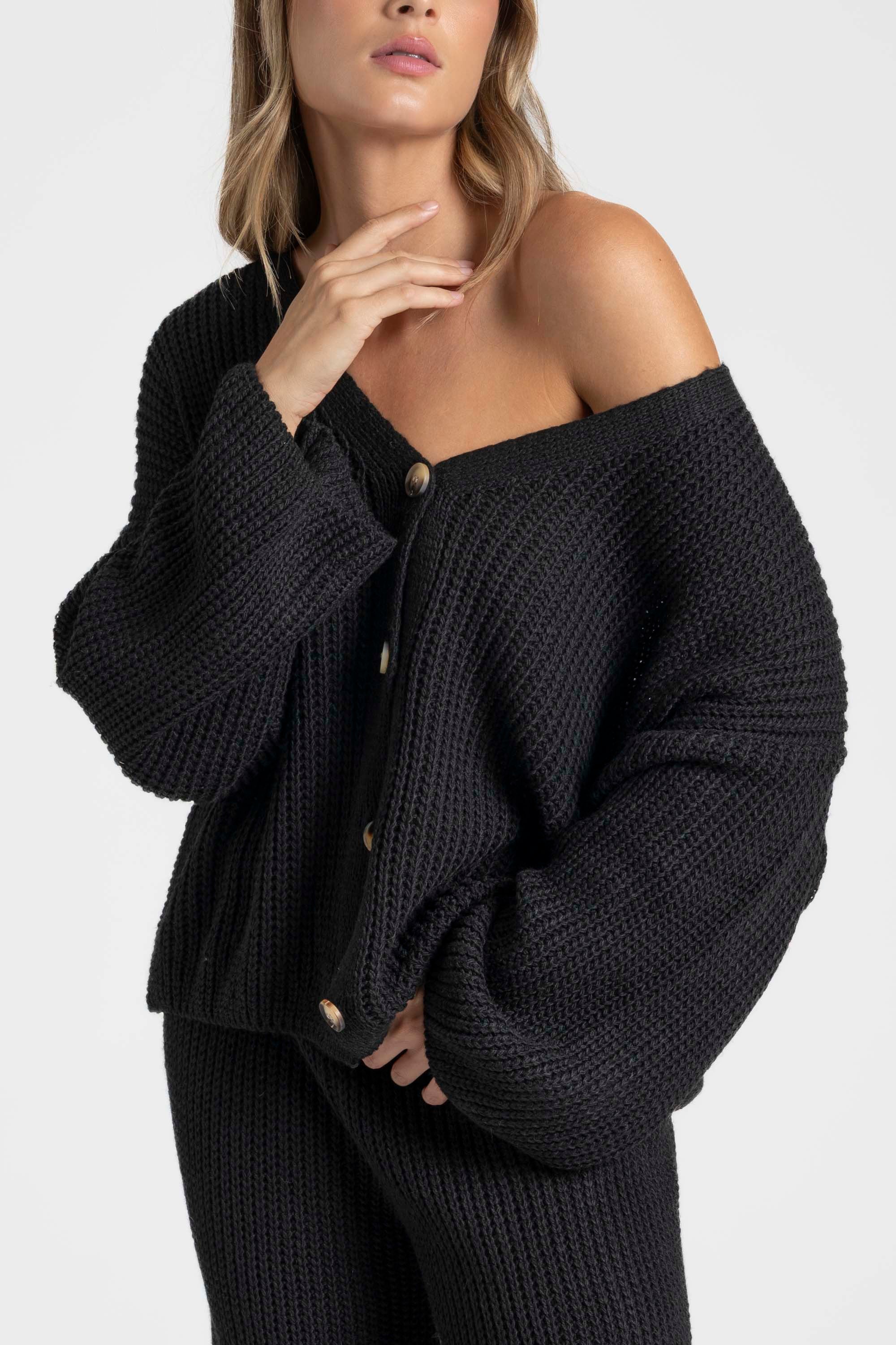 Gros plan sur le haut d'un ensemble maille femme italien, col V boutonné, porté par une femme.