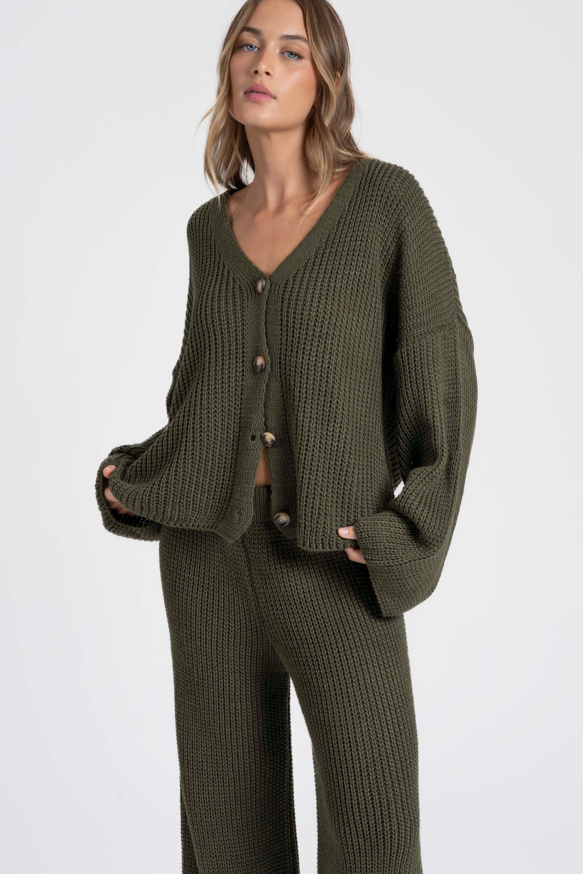 Femme portant un ensemble maille femme italien en olive, debout avec un style décontracté.
