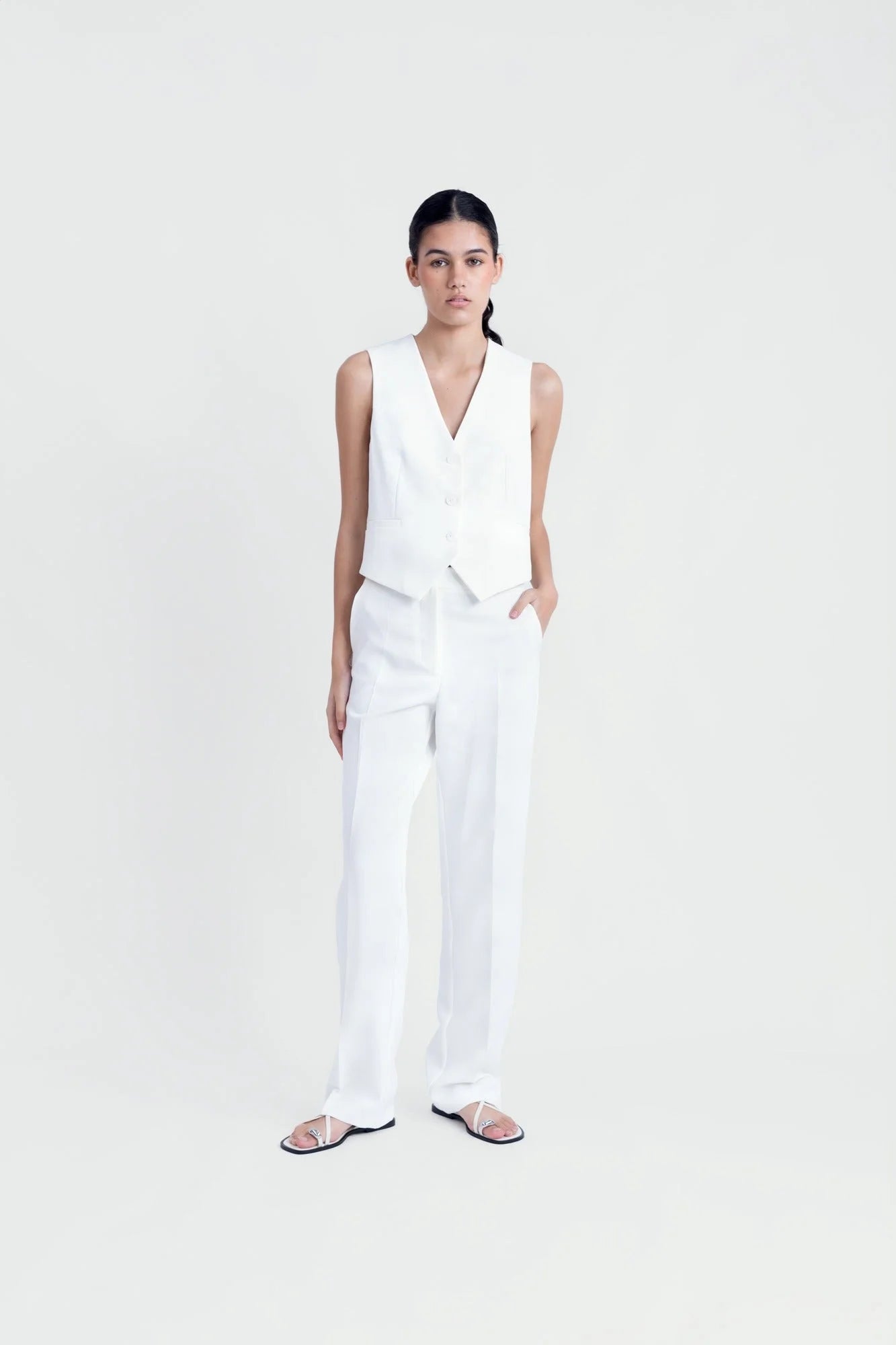 Gilet blanc sans manches coupe tailleur chic avec pantalon large ajusté pour femme
