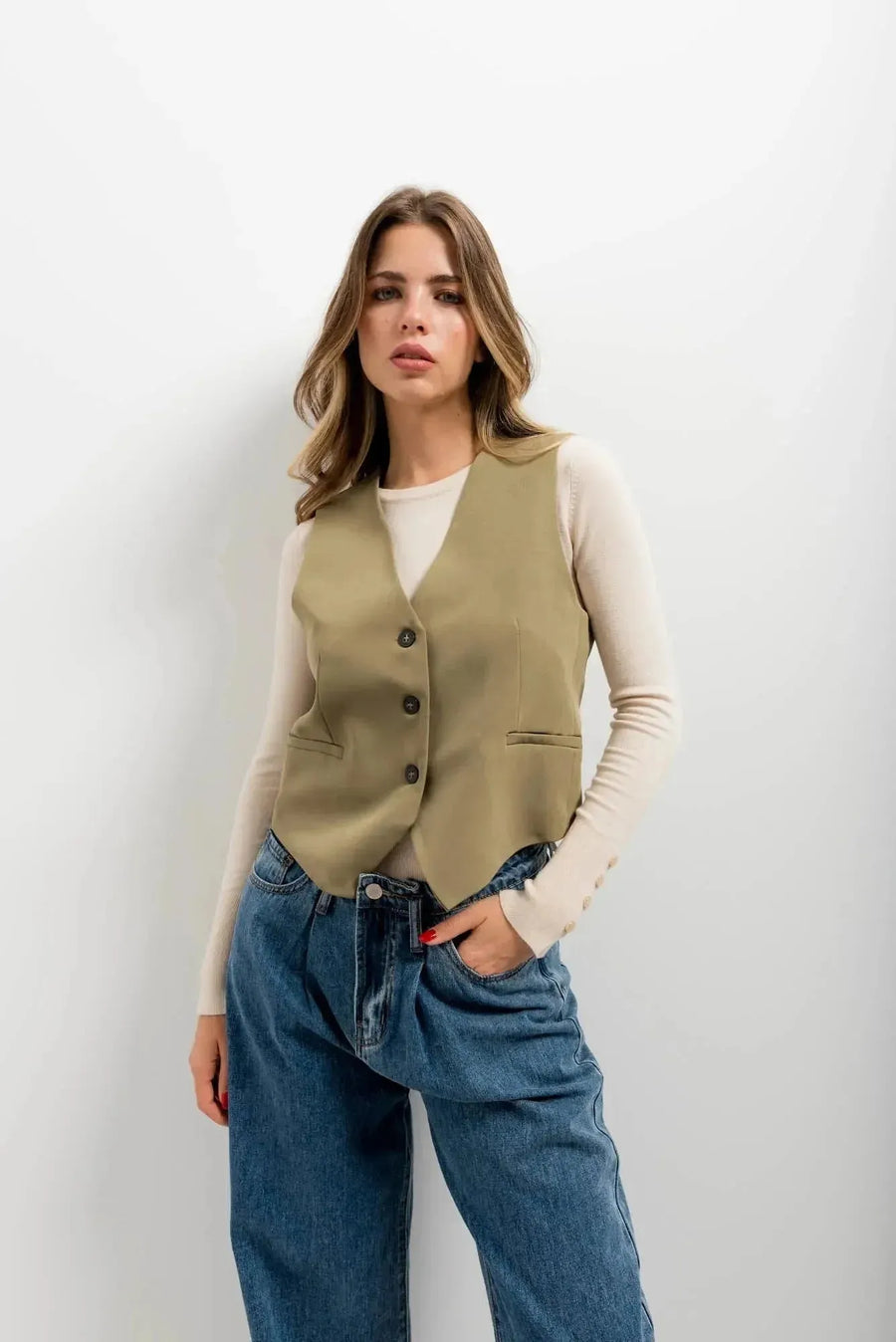 Détail d'une femme dans un gilet élégant vert facile à assortir, un gilet court sans manche femme, avec un regard assuré et un style moderne.