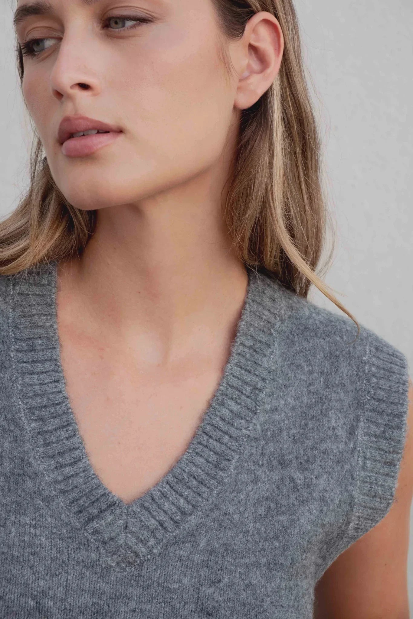 Femme portant un gilet tricoté gris col V pour un look élégant et confortable