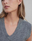 Gros plan sur un gilet tricoté femme col V gris, montrant la texture douce et moderne. Ce gilet tricot sans manche femme est idéal pour superposer.