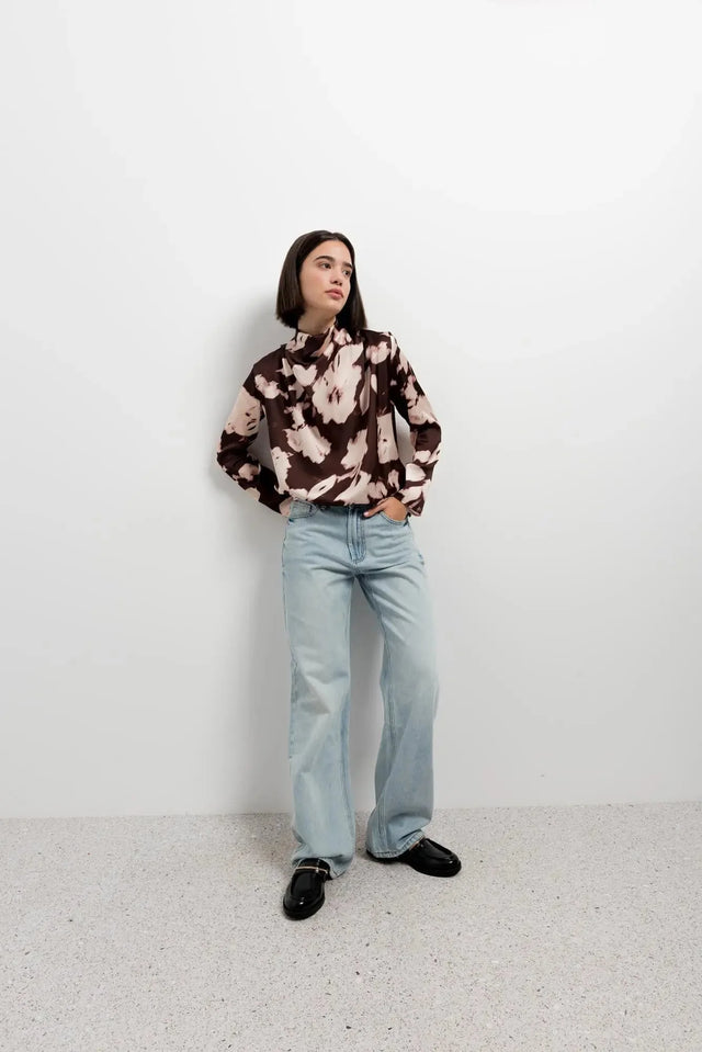 Portrait du modèle avec la blouse femme à col bénitier et imprimé abstrait, capturant l'élégance et le confort de la tenue.