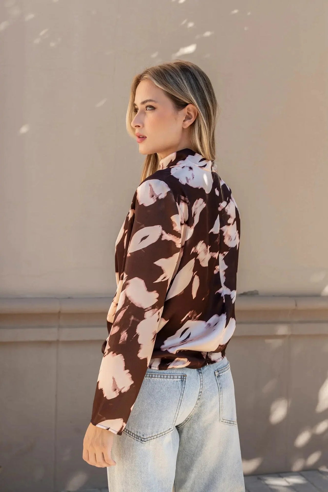 Vue latérale du modèle avec la blouse femme à col bénitier et imprimé abstrait, mettant en valeur la coupe élégante.