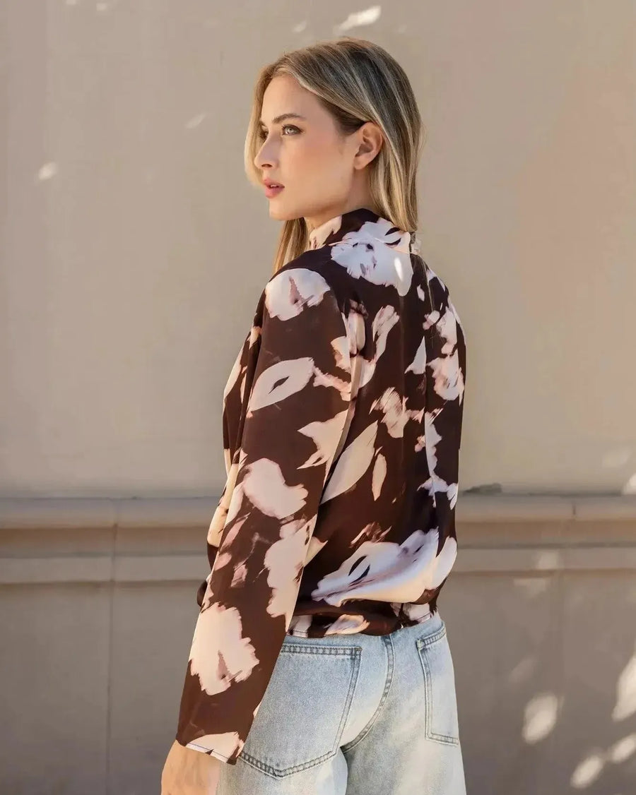 Vue latérale du modèle avec la blouse femme à col bénitier et imprimé abstrait, mettant en valeur la coupe élégante.