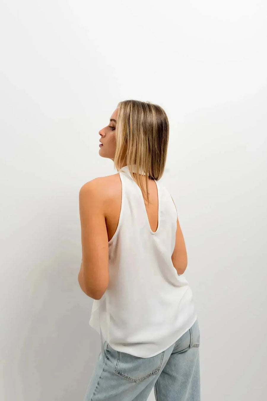 Vue arrière de haut à volants femme chic en tissu lisse, mettant en valeur le design moderne et élégant.