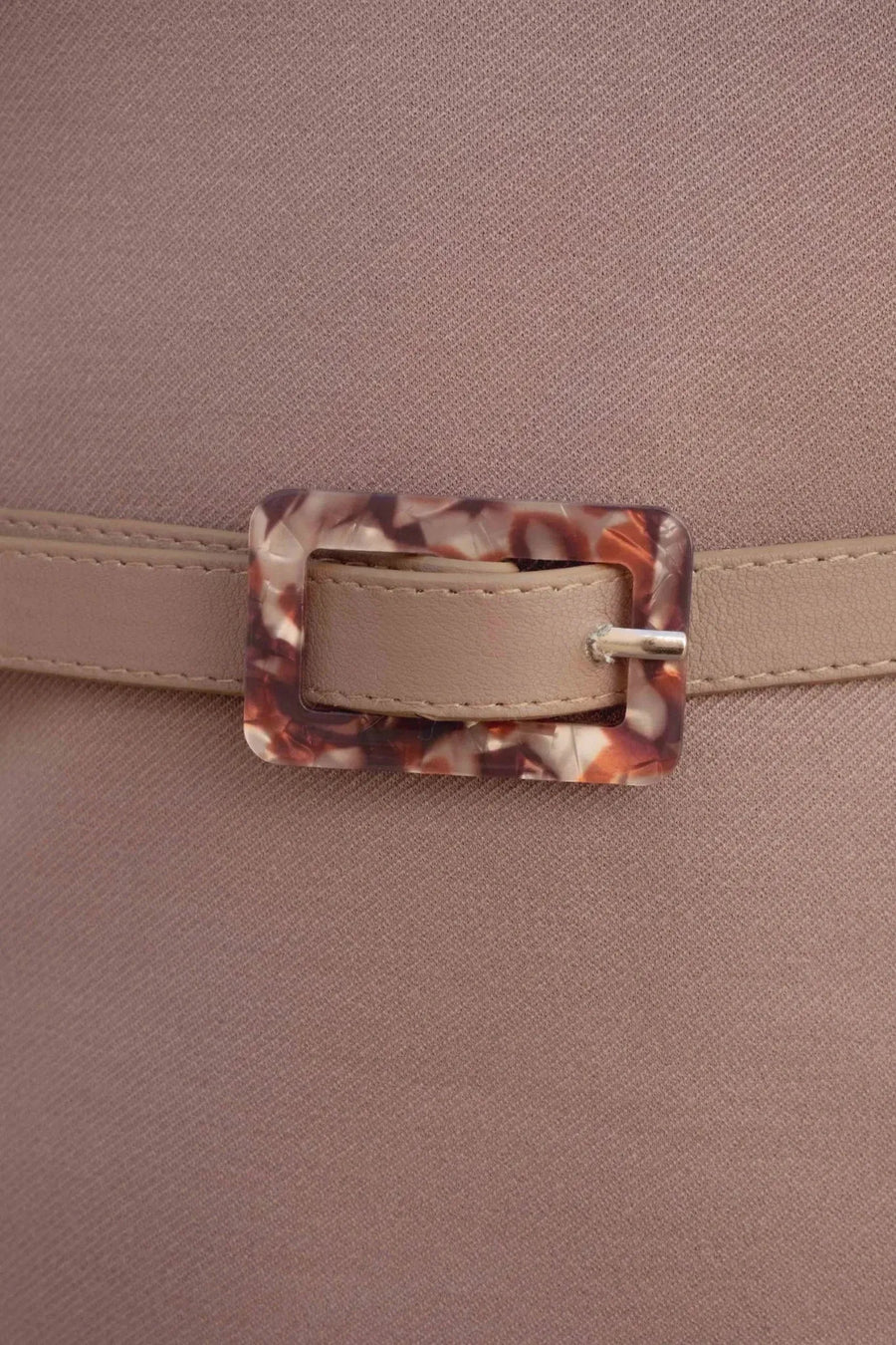 Zoom sur la boucle effet écaille du haut chic femme, mettant en avant les détails raffinés de la ceinture.