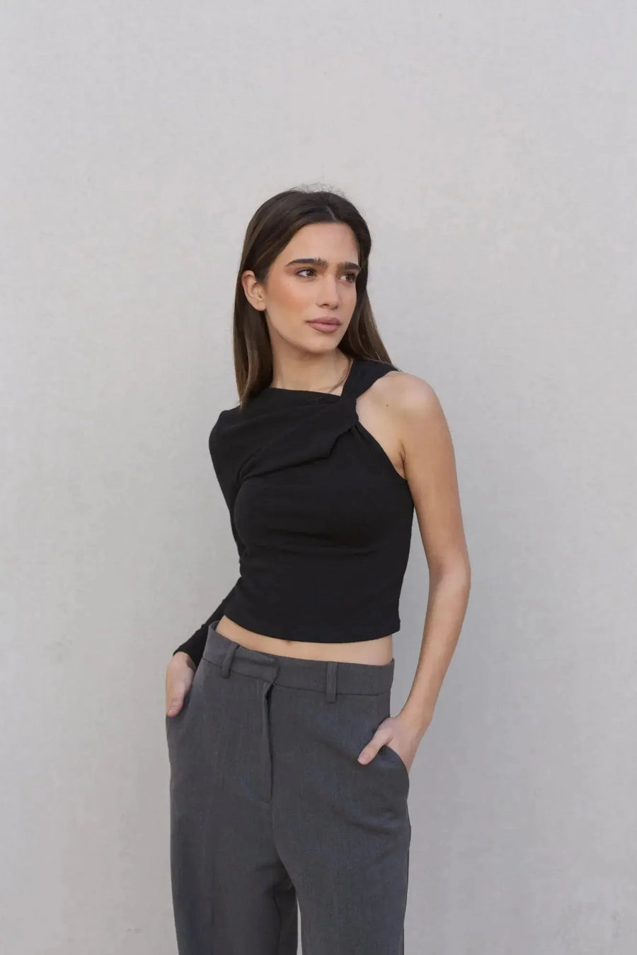 Haut asymétrique femme noir à une épaule, en gros plan, montrant le design sophistiqué et élégant.