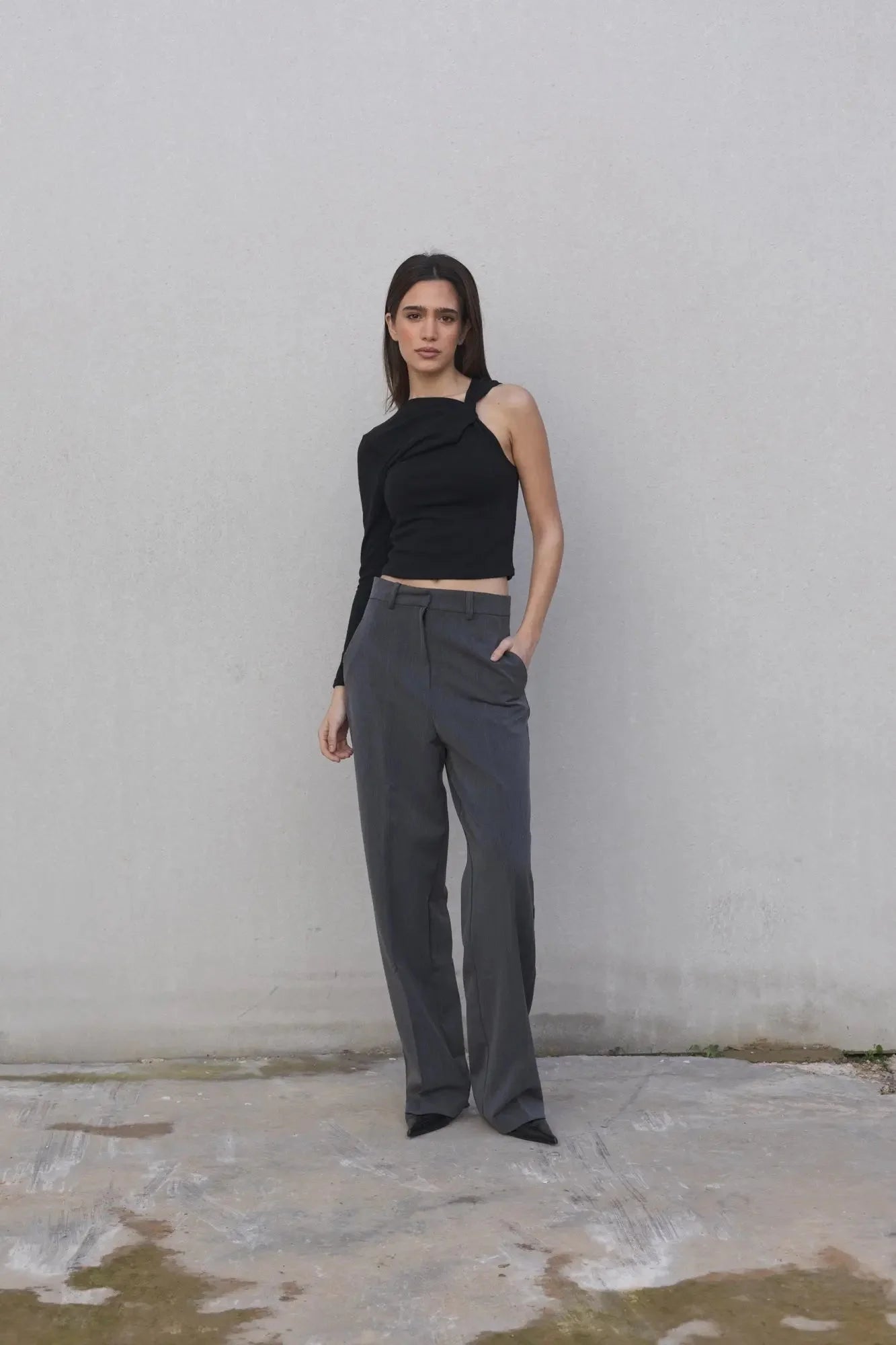 Haut asymétrique beige clair à une épaule porté avec pantalon large gris foncé