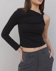 Haut asymétrique femme noir à une épaule, avec une pose qui met en avant le style contemporain et le confort.