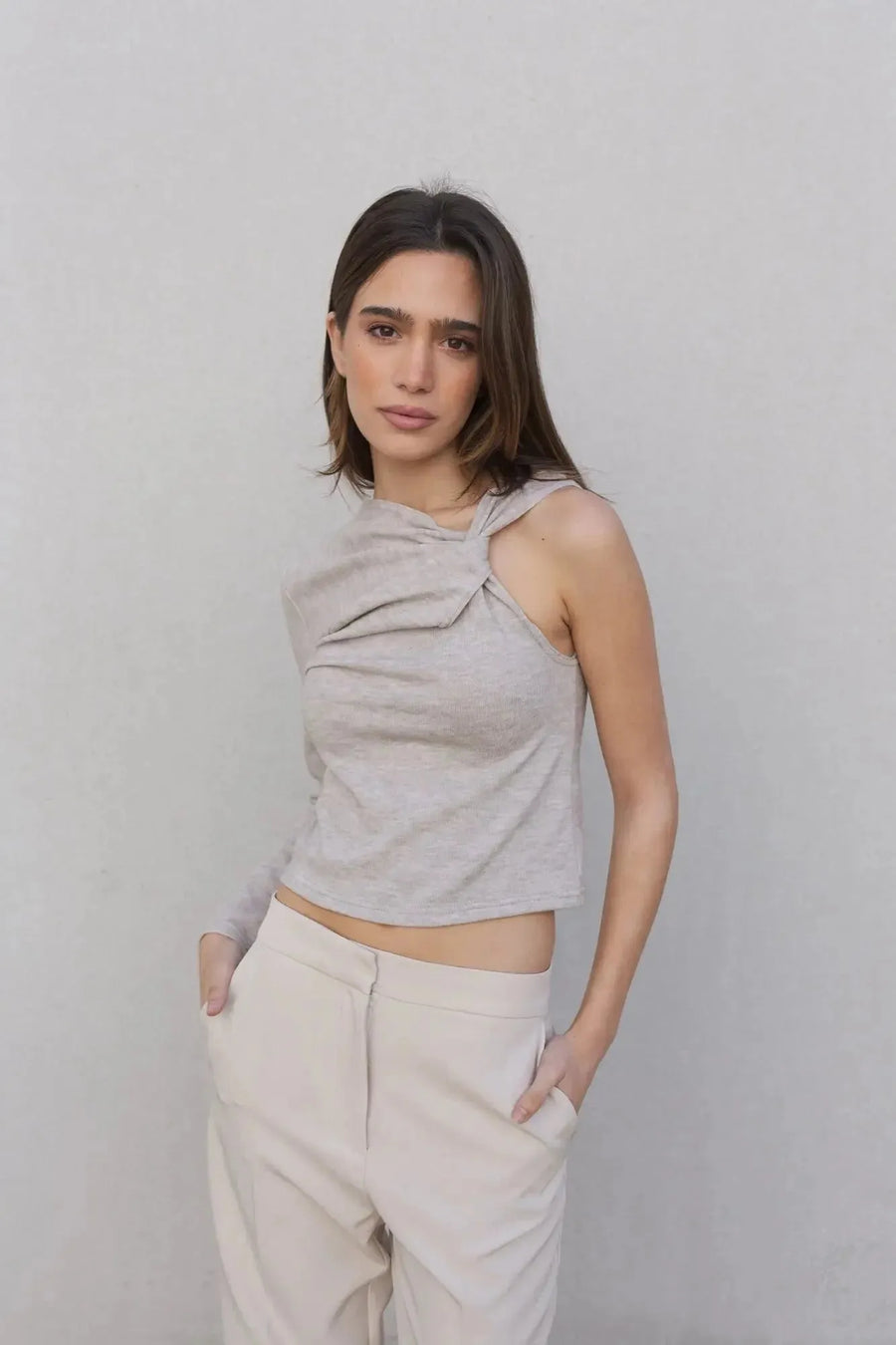 Haut asymétrique femme beige clair à une épaule, en gros plan, mettant en valeur le design unique et stylé.
