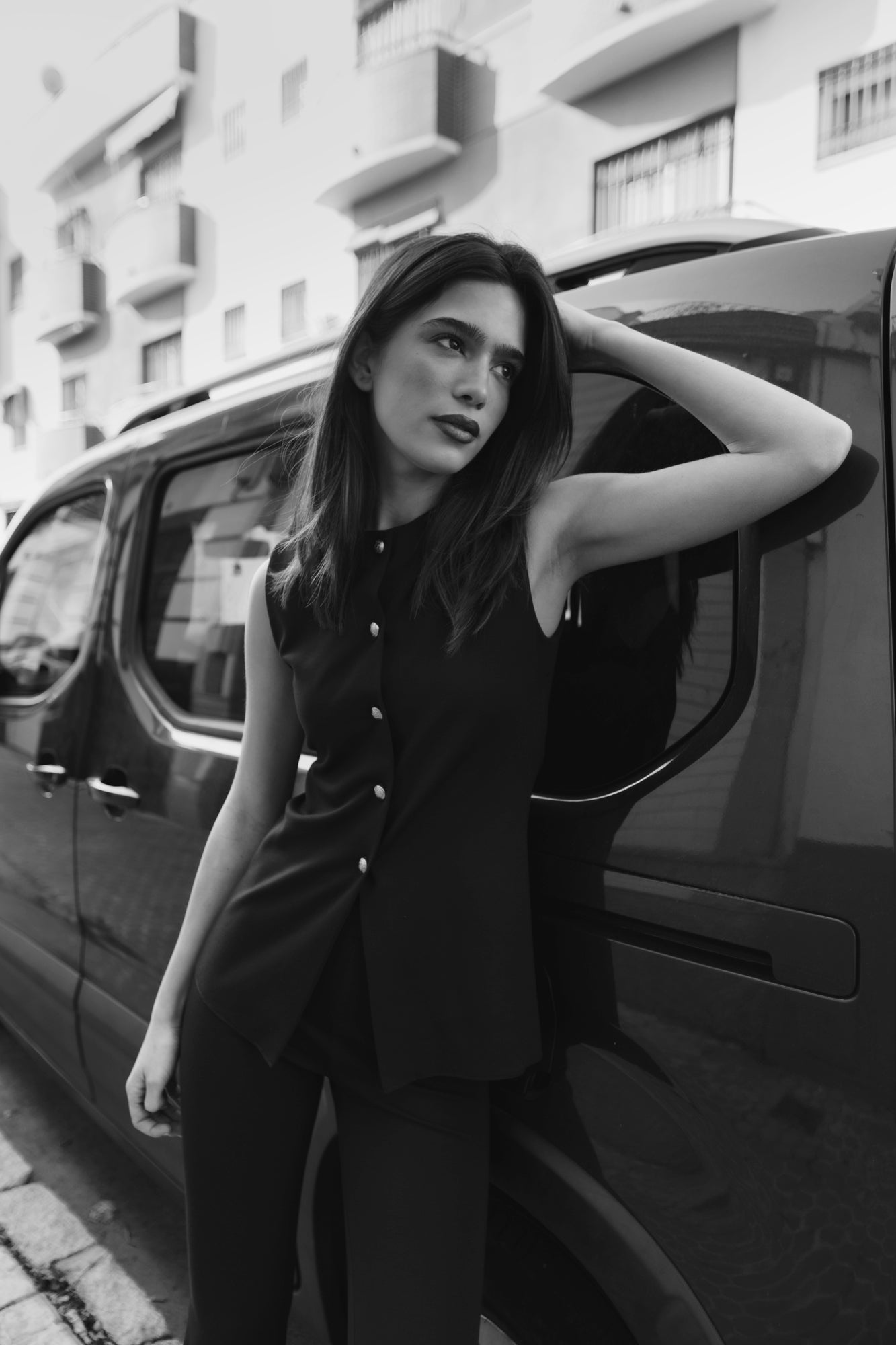 Haut gilet noir femme sans manches avec boutons dorés, coupe structurée