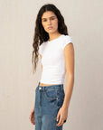 Détail d'une jeune femme vêtue d'un tee-shirt blanc, mettant en valeur son jean à jambe large et ourlets retroussés, parfait pour un look jean ample femme.
