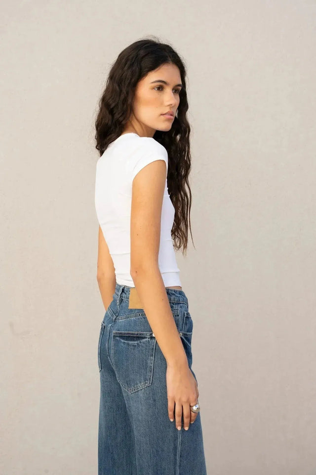 Profil d'une jeune femme portant un jean à jambe large et ourlets retroussés, illustrant le confort et l'élégance du jean ample femme.