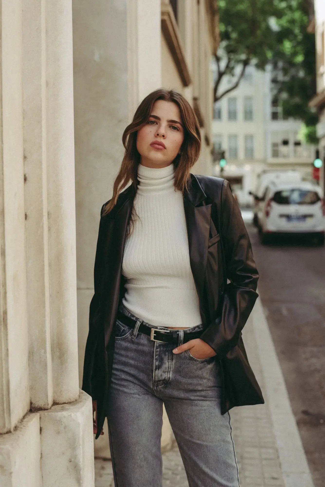 Femme portant des jeans taille haute coupe droite avec blazer noir et turtleneck blanc