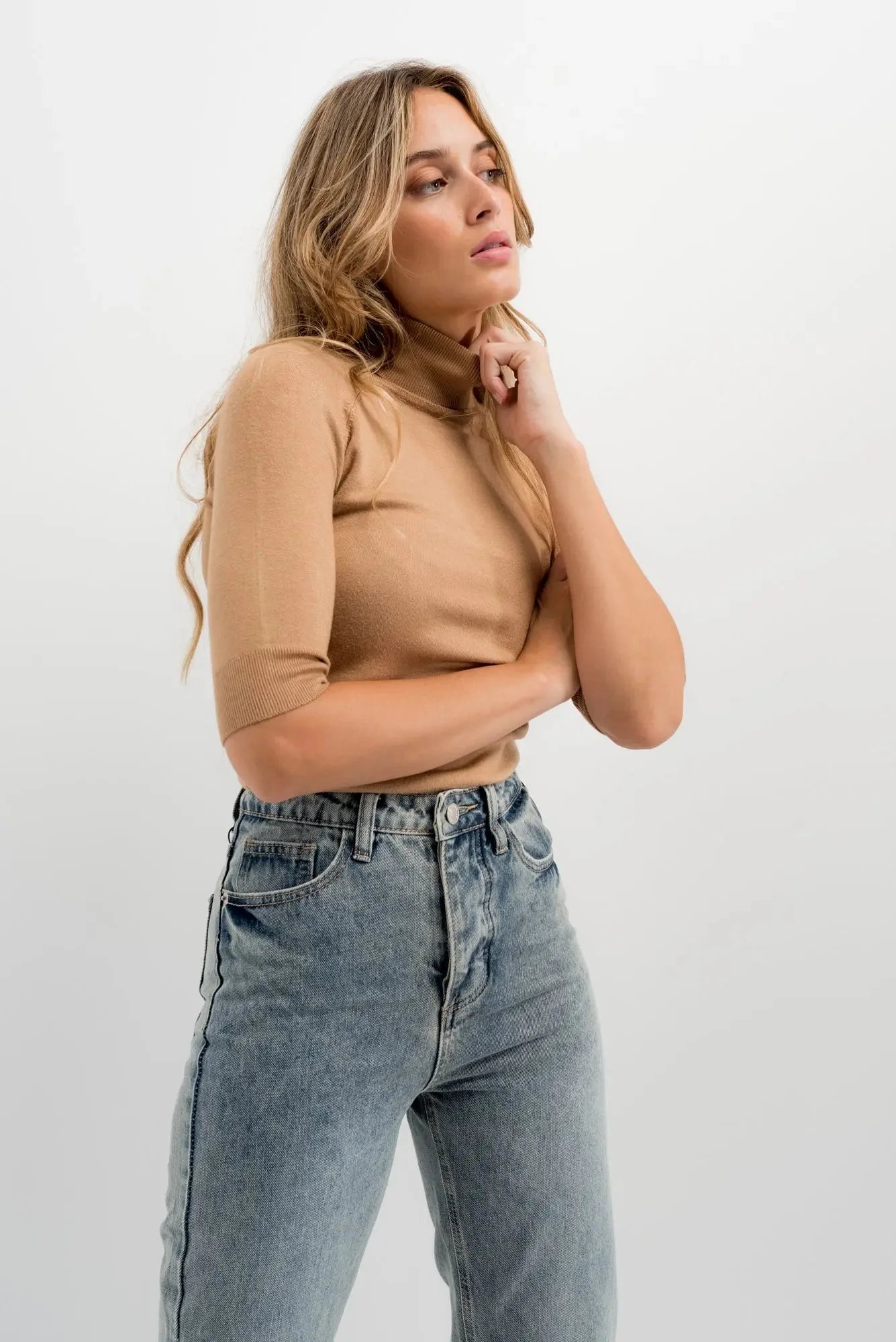 Femme portant un haut turtleneck léger et jeans taille haute coupe droite