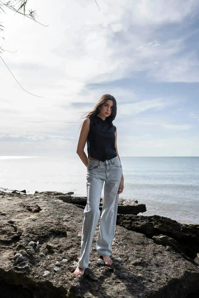 Modèle debout sur des rochers, arborant un Jean Jambe Large à la Coupe Flatteuse, offrant une silhouette flatteuse avec le jean jambe large femme.