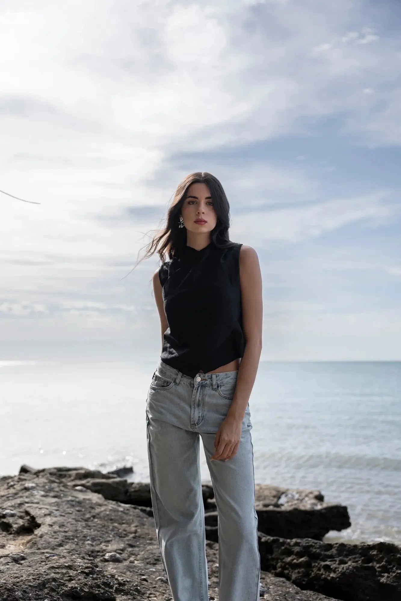 Femme portant un jean jambe large noir sans manches et jeans bleu clair