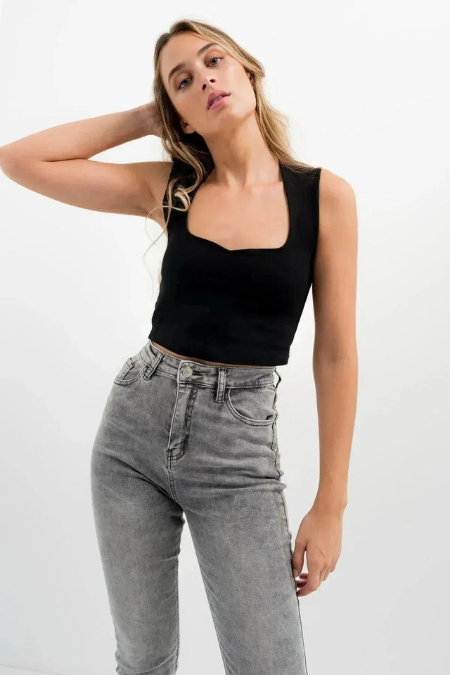 Jean Skinny Femme Taille Haute Sculptant Gris - Confort Optimal & Silhouette Sublimée, connu pour sa coupe skinny, porté par une femme en haut noir et jeans gris.