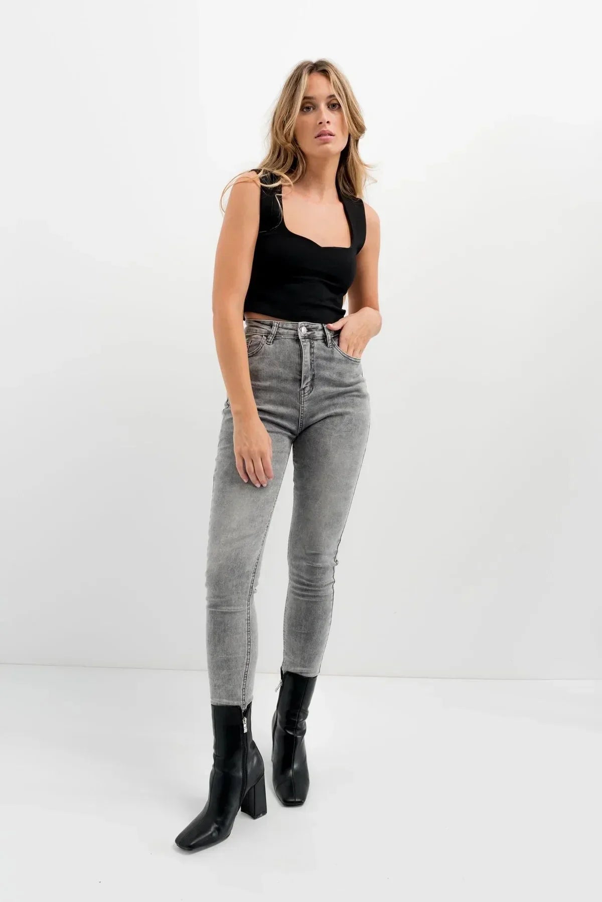 Top sans manches noir femme avec décolleté en cœur et jean sculptant taille haute gris