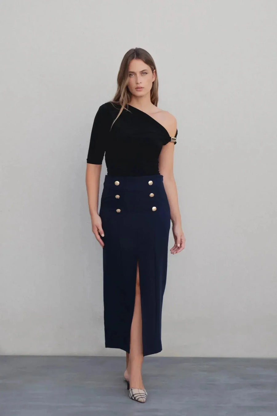 Vêtements femme à boutons dorés : top noir asymétrique et jupe marine à fente