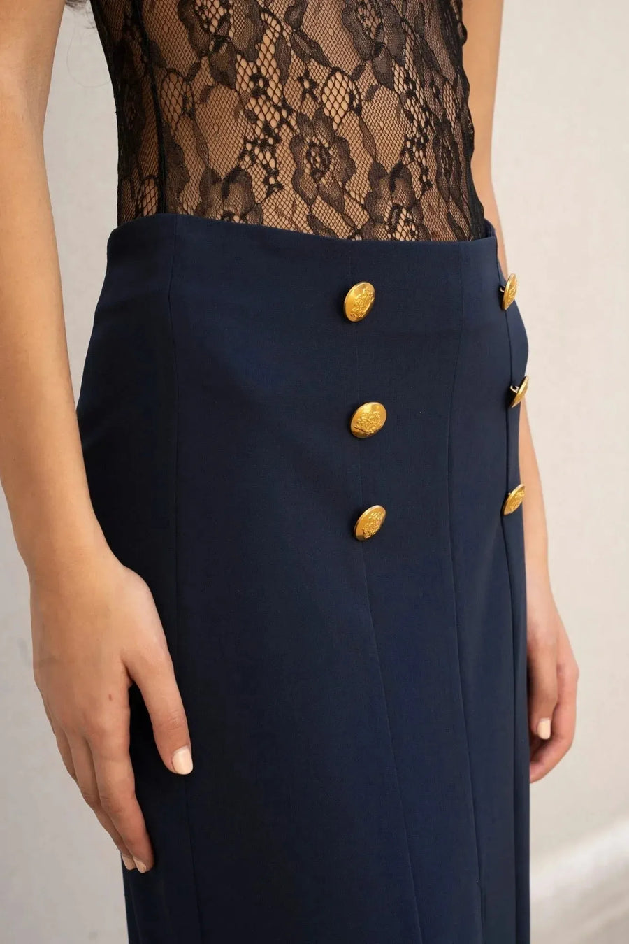 Jupe femme marine à boutons dorés et top en dentelle noire, style femme à boutons