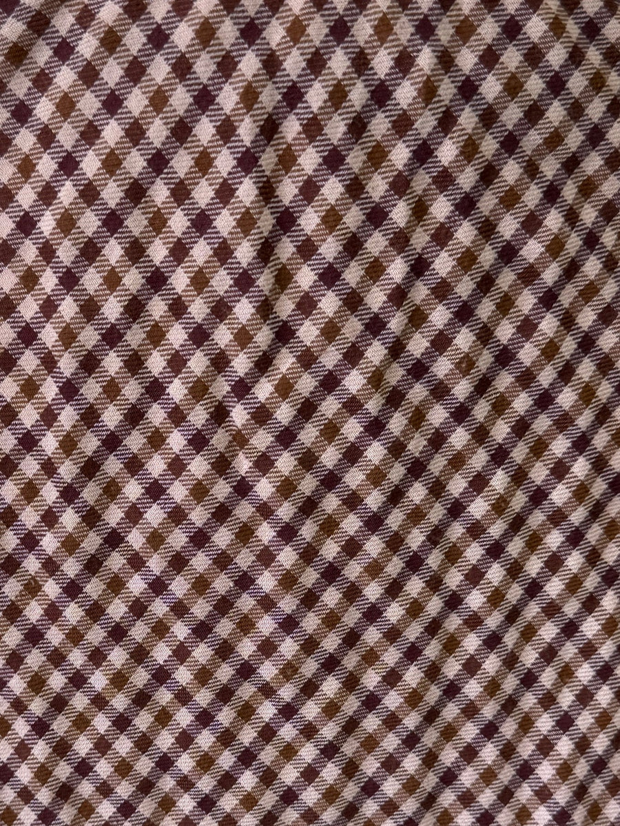 Gros plan sur le motif à petits carreaux marron et clairs de la jupe.