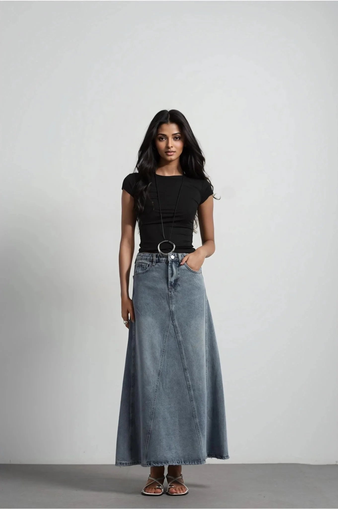 Jeune femme en jupe jean femme bleu délavé élégante et confortable, regardant vers l'appareil photo, idéale pour un style décontracté ou chic.