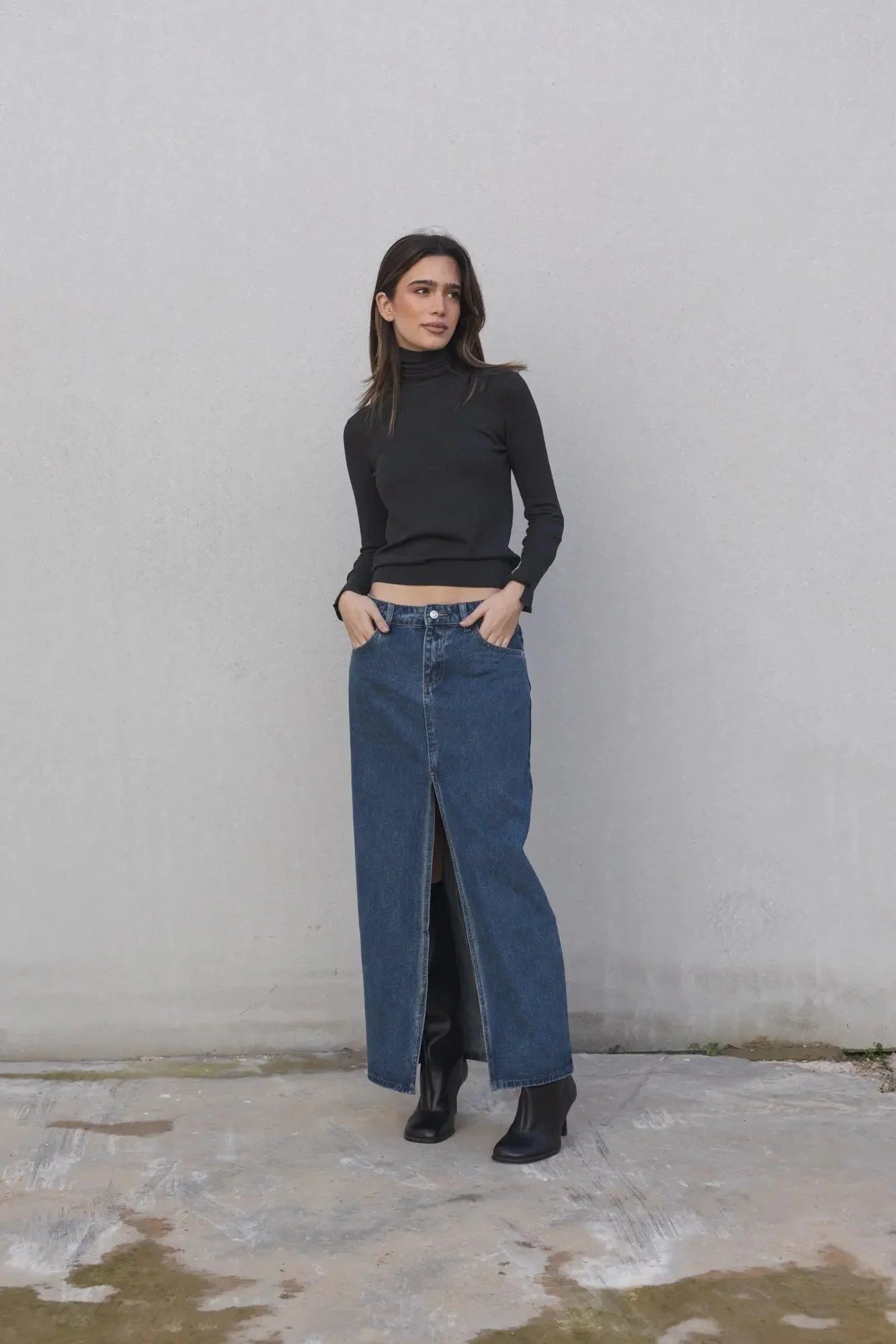 Modèle portant une jupe jean longue avec fente haute, alliant confort et élégance moderne pour un look polyvalent. Parfaite pour toutes les occasions.