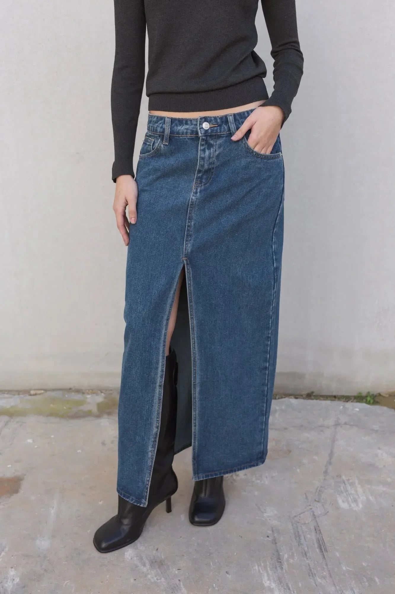 Détail sur une jupe jean longue avec fente haute, mettant en avant le design tendance et la praticité pour un look stylish en toutes situations.
