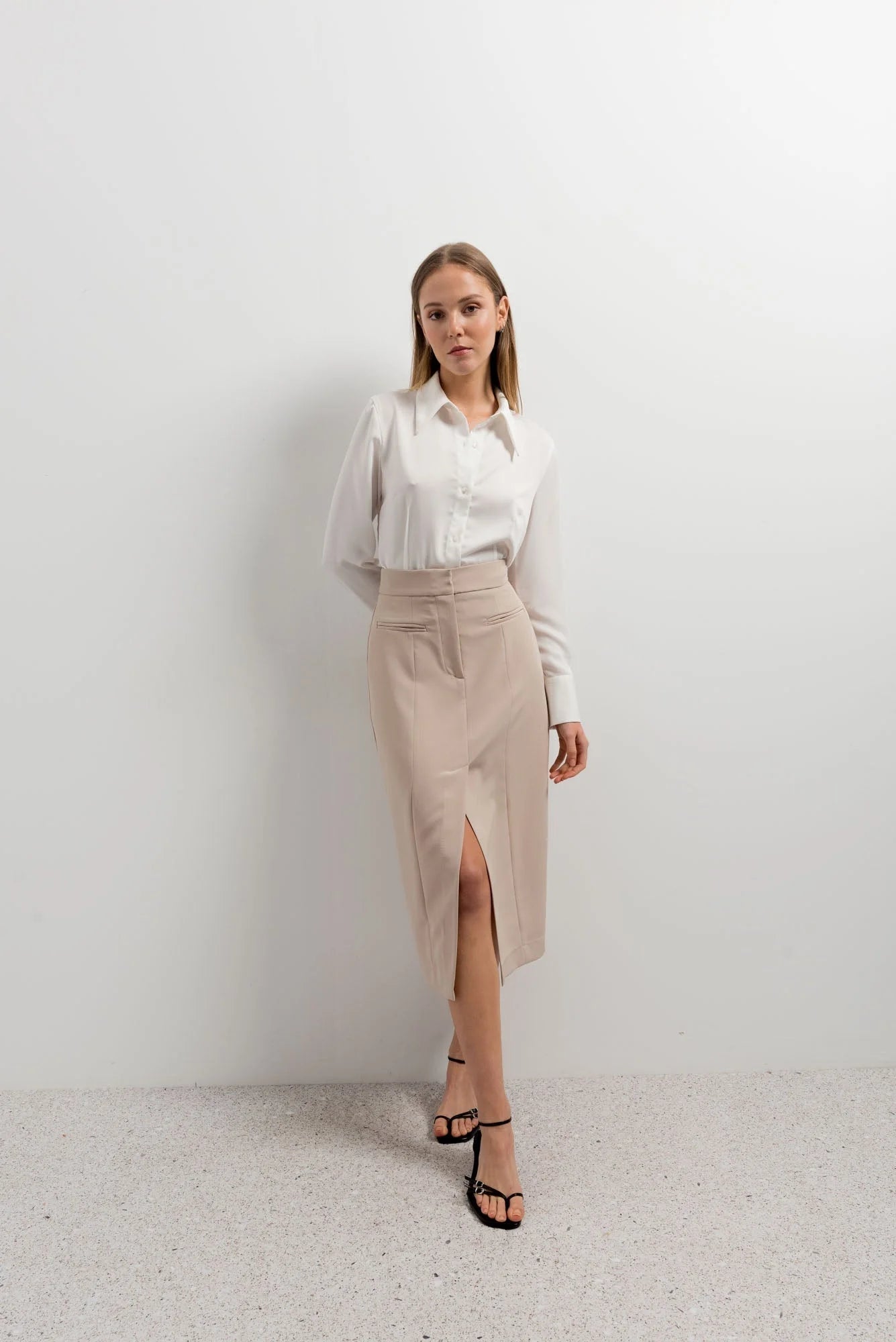 Alt text pour jupe mi-longue fendue chic : jupe mi-longue beige avec fente et boutons élégants