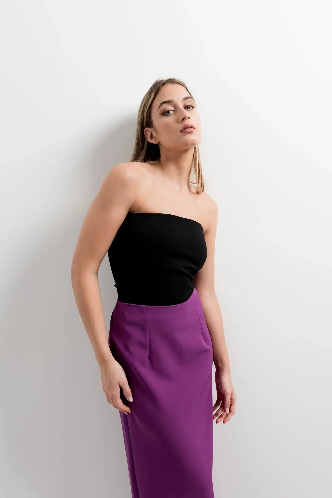Femme portant une jupe midi avec fente latérale et haut noir pour un look élégant