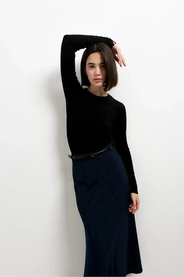 Modèle portant une jupe avec ceinture, élégante jupe midi en coloris navy, parfaite pour un look chic et décontracté.