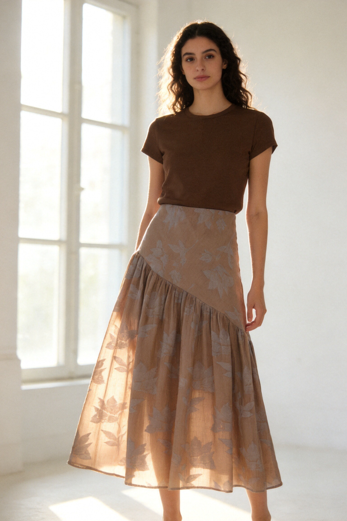 Jupe midi taupe en jacquard floral, portée de face dans un intérieur lumineux