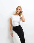 Jupe Midi Noir et Blanc Élégante et Confortable - Plan rapproché d'une femme avec haut blanc tenant une jupe midi noir et blanc, mettant en avant le style élégant.