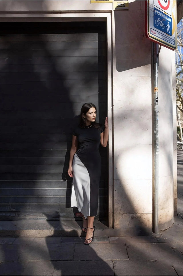 Jupe Midi Noir et Blanc Élégante et Confortable - Femme stylée posant dans une rue, vêtue d'une jupe midi noir et blanc, parfaite pour un look de jour chic.