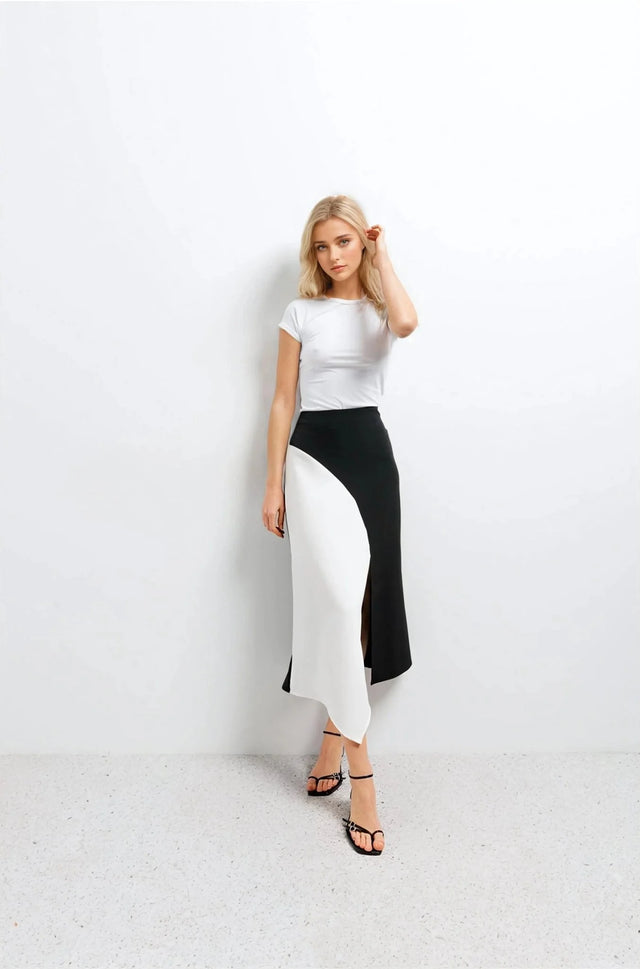 Jupe Midi Noir et Blanc Élégante et Confortable - Femme élégante portant une jupe midi noir et blanc avec un haut blanc, style polyvalent pour toutes occasions.