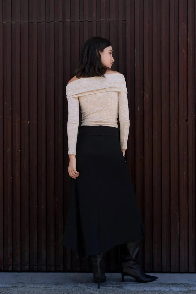 Femme de dos dans la Jupe Midi Noire Avec Ceinture, mettant en avant la coupe moderne et la taille haute, idéale pour toutes les silhouettes.