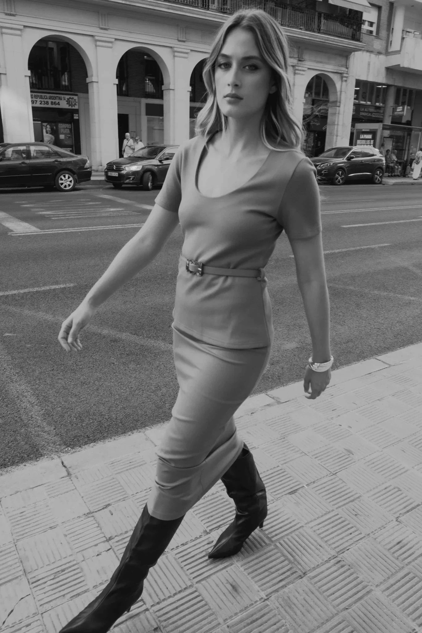 Femme en jupe midi taupe, robe courte à col en ville avec bottes hautes