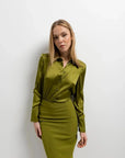 Modèle en jupe verte satin longue et blouse assortie, posant avec style pour mettre en avant l'élégance de cette pièce.